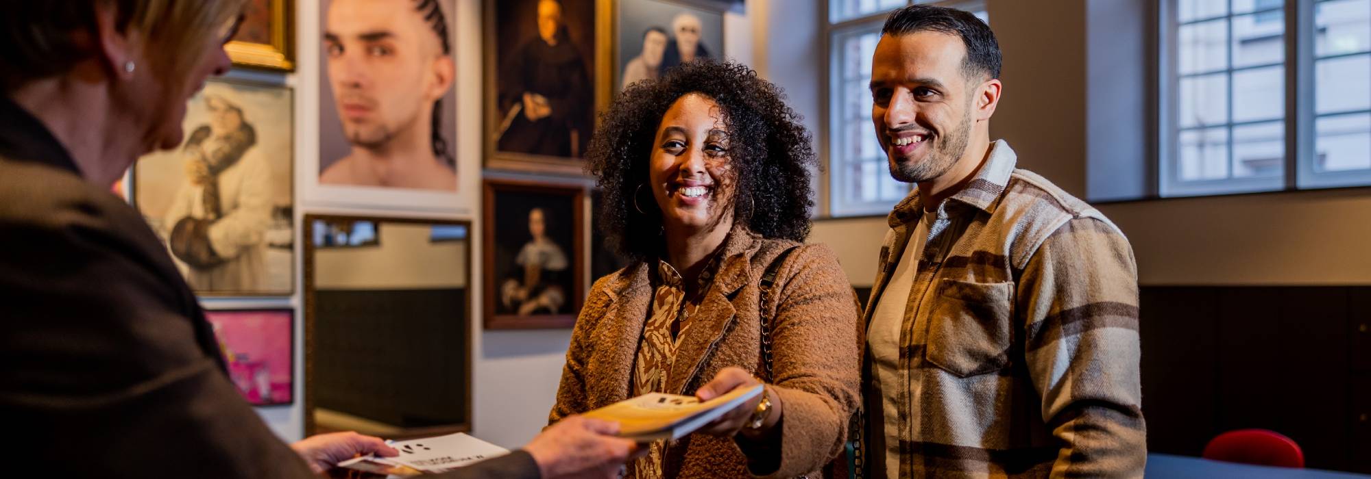 Bezoekers ontvangen een gids bij Museum W in Weert na een treinreis met NS-korting naar Museum W.