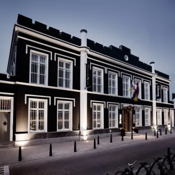 Vooraanzicht van het statige gebouw van Het Arresthuis in Roermond, een voormalige gevangenis omgebouwd tot luxe hotel.