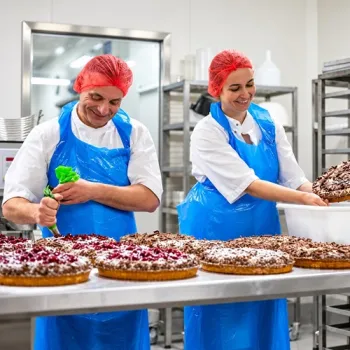 Twee bakkers van Bakkerij Heerschap werken in de bakkerij aan versgebakken vlaaien.